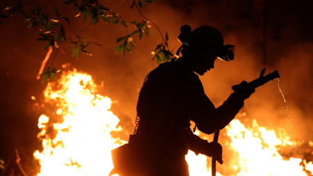 Cal Fire firefighter Trevor Smith battles the Tubbs Fire near Calistoga, Calif., on Thursday. Wildfires in Northern California have killed dozens of people and destroyed thousands of homes and businesses.