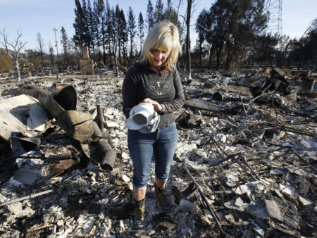 Debbie Wolfe looks at the antique pitcher that once belonged to her grandmother after finding it in the burned ruins of her home on Tuesday in Santa Rosa, Calif.