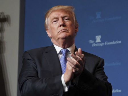 President Trump applauds members of the audience before speaking at the Heritage Foundation's annual President's Club meeting on Tuesday evening.