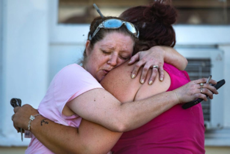 Carrie Matula hugs Rebecca Metcalf after Metcalf's father was killed in a mass shooting at the First Baptist Church in Sutherland Springs, Texas, on Sunday, Nov. 5, 2017.