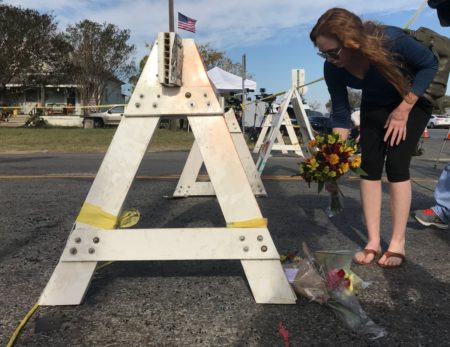 A few people lay flowers in front of the First Baptist Church in Sutherland Springs, Texas.