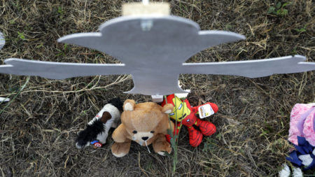 Stuffed animals sit at the base of a cross at a makeshift memorial for victims in Sutherland Springs, Texas.