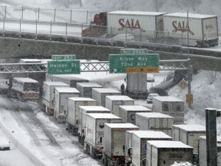 Early morning traffic backs up on Interstate 5 during a Jan. 11 snowstorm in Portland, Ore. Truck drivers say such conditions, combined with limitations on their working hours, cost them a lot of money because of their mileage-based pay.