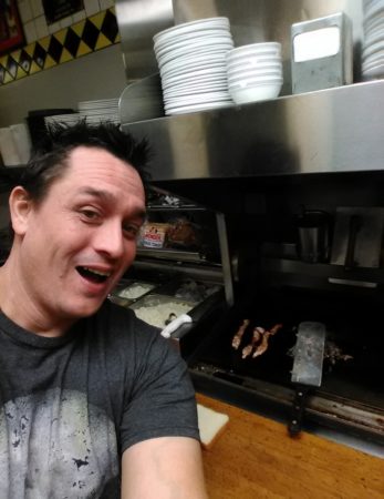 Alex Bowen poses in front of a griddle at a Waffle House in West Columbia, S.C., on Thursday. When Bowen found the only worker at the empty restaurant asleep, he took his meal into his own hands.