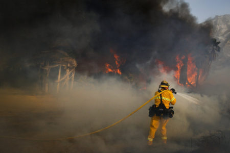 A firefighter battles a wildfire on Thursday at Faria State Beach in Ventura, Calif.