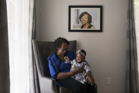Wanda Irving holds her granddaughter, Soleil, in front of a portrait of Soleil's mother, Shalon, at her home in Sandy Springs, Ga. Wanda is raising Soleil since Shalon died of complications due to hypertension a few weeks after giving birth.