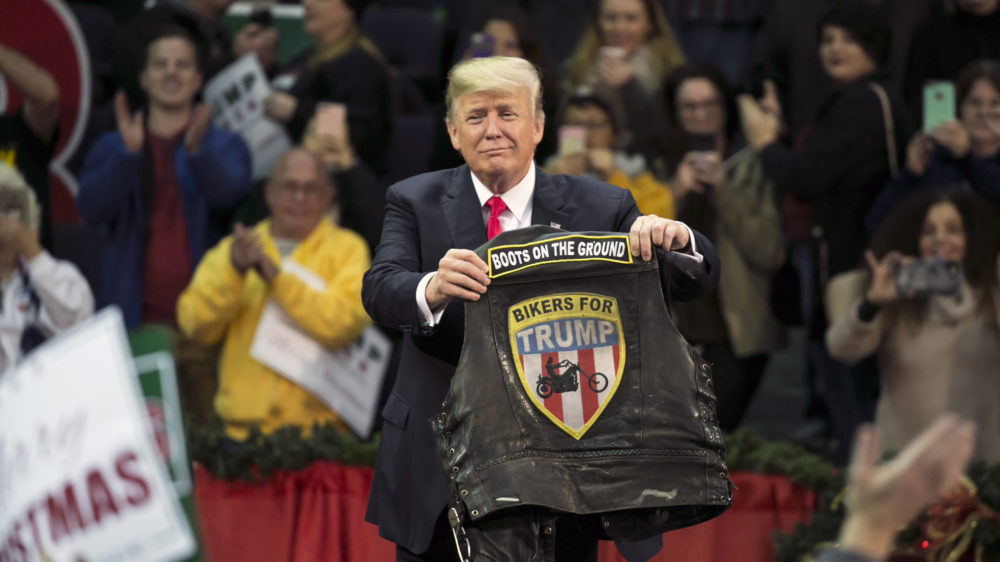President Trump holds a vest reading "Bikers For Trump" during a rally in Pensacola, Fla., Friday. There, he gave his most full-throated endorsement of Roy Moore for Senate in Alabama yet.