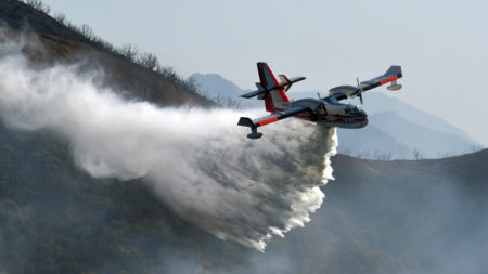 In this photo provided by the Santa Barbara County Fire Department, a Bombardier 415 Super Scooper makes a water drop on hot spots along the hillside east of Gibraltar Road in Santa Barbara, Calif., on Sunday morning.