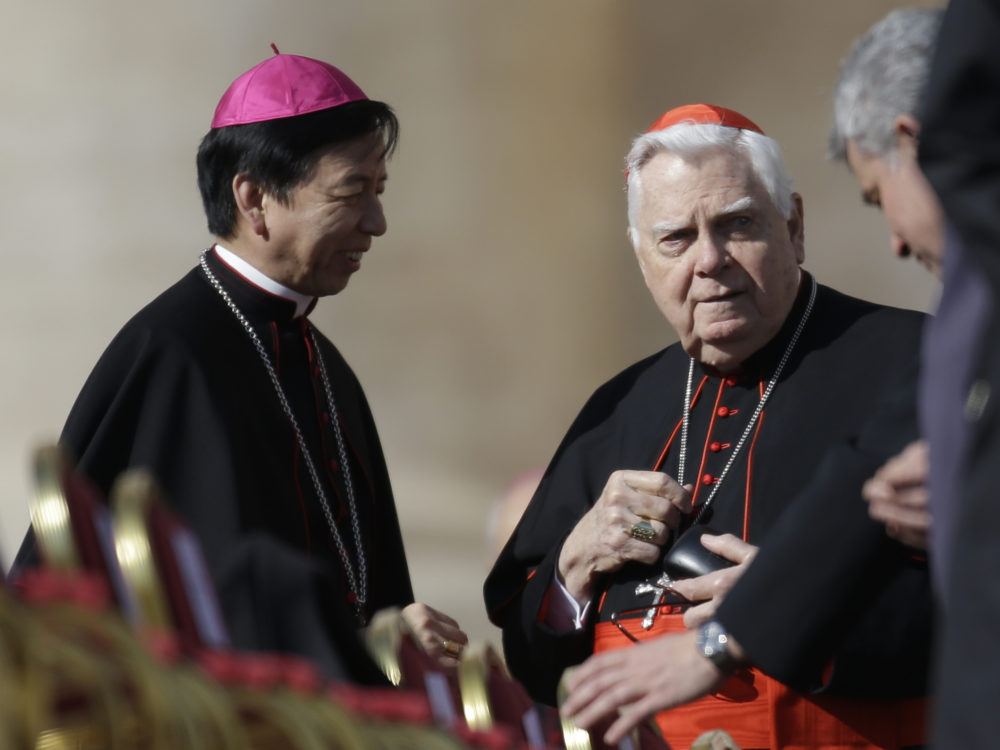 Cardinal Bernard Law (right) speaks with unidentified prelates as he attends Pope Benedict XVI's last general audience in St. Peter's Square at the Vatican in 2013
