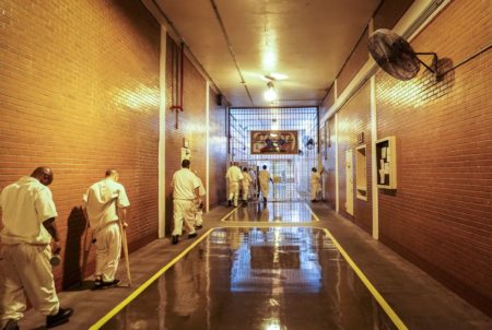 Inmates shuffle past new fans in the Darrington prison's main hallway on a hot July day.
 Inmates shuffle past new fans in the Darrington prison's main hallway on a hot July day.