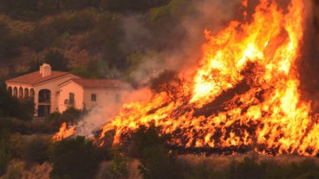 In this Thursday, Dec. 14, 2017, shows flames from a back firing operation underway rise behind a home off Ladera Ln near Bella Vista Drive in Santa Barbara, Calif.
