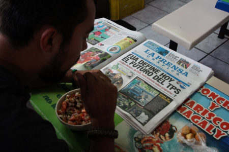 A Salvadoran man reads a newspaper at a market in San Salvador on January 8. The newspaper headline reads: "The United States will decide today the future of TPS."