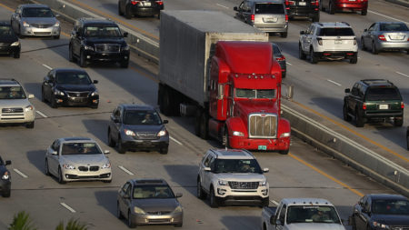 A tractor-trailer rolls along the highway in Miami last November. The trucking industry needs to hire almost 900,000 more drivers to meet rising demand, according to an industry analysis.