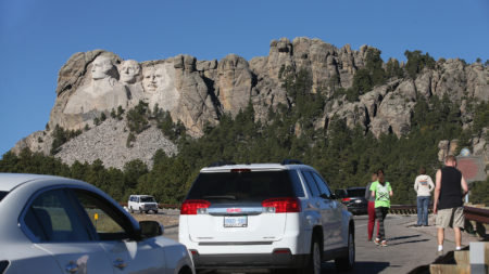 During the 2013 shutdown, tourists have to look at Mount Rushmore from the highway because the national memorial in Keystone, S.D., was close