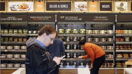 Shoppers roam through an Amazon Go store in April. The automated grocery, which had been restricted to Amazon employees, will be open to the public starting Monday.