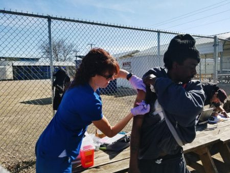 Alicia Coomes gives Michael Houston a flu shot at the roving flu clinic station, set up to help Fort Worth's homeless.