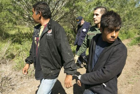 Border Patrol Agent Roberto Rodriguez escorts two Mexican nationals apprehended near the Texas-Mexico border on Oct. 12, 2017.
