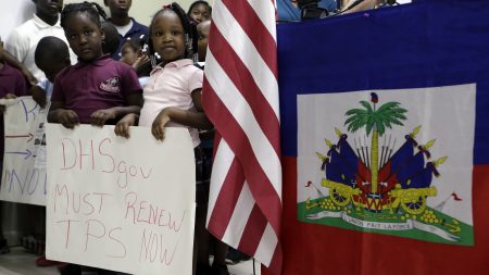Children hold signs at a November news conference in Miami in support of renewing temporary protected status for immigrants from Central America and Haiti.