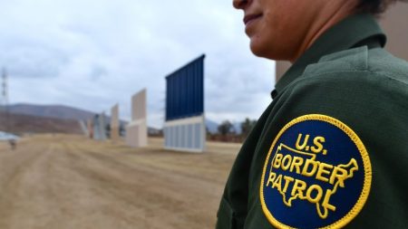 A U.S. Border Patrol officer stands near prototypes of President Trump's proposed border wall in San Diego last November.