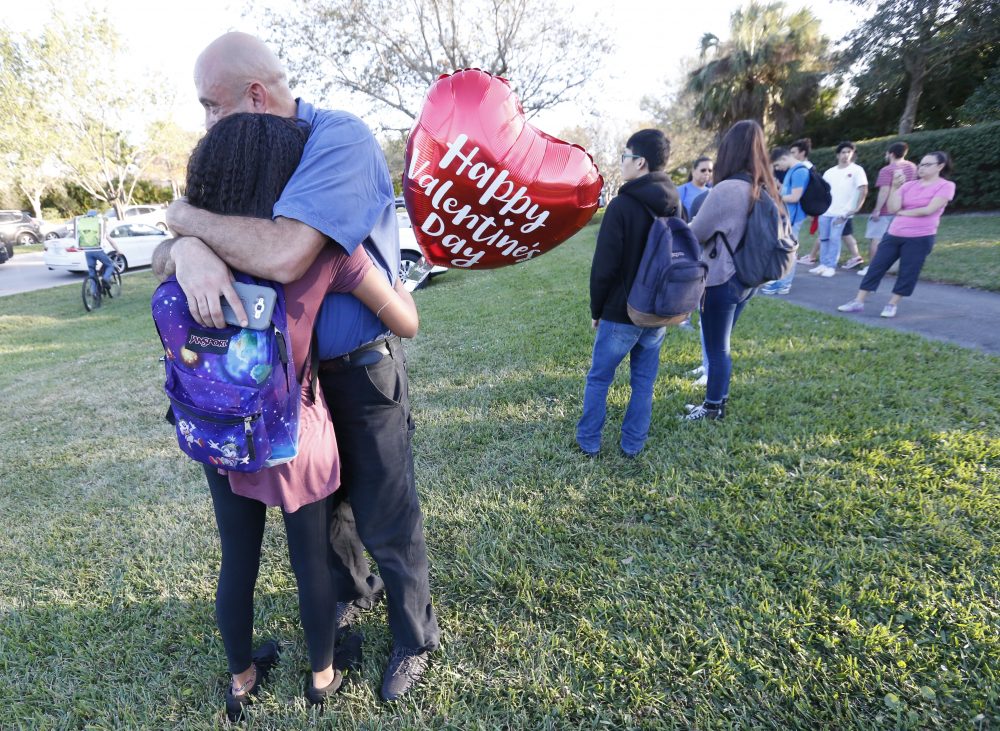 Family member embrace following a shooting at Marjory Stoneman Douglas High School, Wednesday, Feb. 14, 2018, in Parkland, Fla. (AP Photo/Wilfredo Lee)