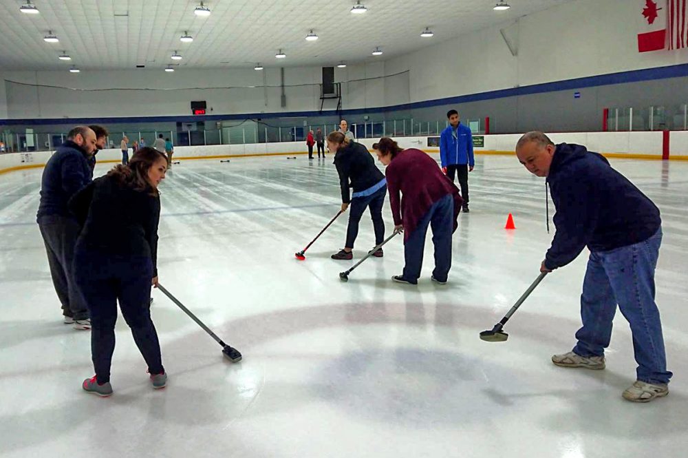 Sweepers at one of the Houston Curling Club's "Intro to Curling" sessions.