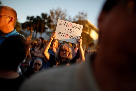 A woman holds a placard during a candlelight vigil for victims of yesterday's shooting at nearby Marjory Stoneman Douglas High School, in Parkland, Florida.