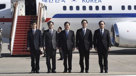 South Korea's national security director Chung Eui-yong, center, National Intelligence Service Chief Suh Hoon, second left, and others in the delegation pose before boarding an aircraft as they leave for Pyongyang at a military airport south of Seoul Monday.