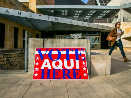 A pedestrian walks past Austin City Hall, an early voting center, on Tuesday in Austin, Texas.