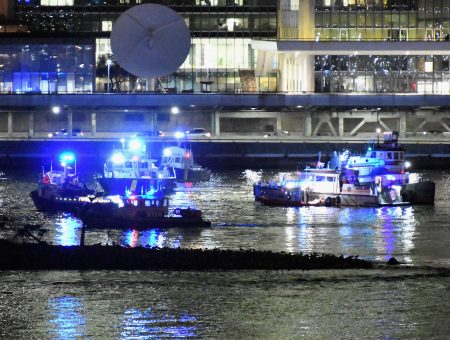 Police and firefighters respond to a helicopter crash into New York City's East River on Saturday evening that left two people dead and three others critically injured.