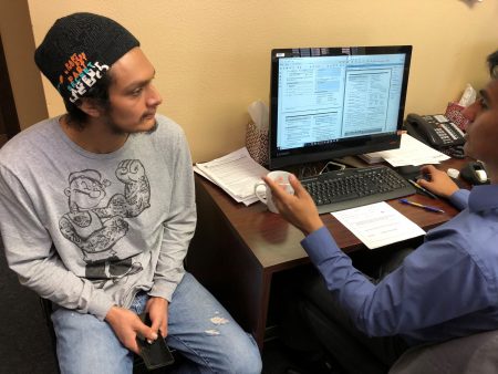 Joel Gómez (right), who works for the organization Center of Central American Resources (known as CRECEN by its acronym in Spanish), assists Jhony Adalbert Bautista (left) with his paperwork to re-register as a recipient of the Temporary Protected Status (TPS) on March 19, 2018 at CRECEN’s office in Houston.