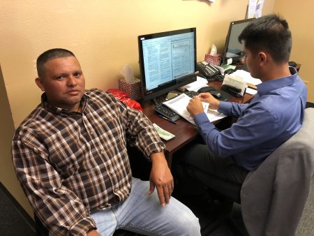 Joel Gómez (right), who works for the organization Center of Central American Resources (known as CRECEN by its acronym in Spanish), assists Martir Velasquez (left) with his paperwork to re-register as a recipient of the Temporary Protected Status (TPS) on March 19, 2018 at CRECEN’s office in Houston.