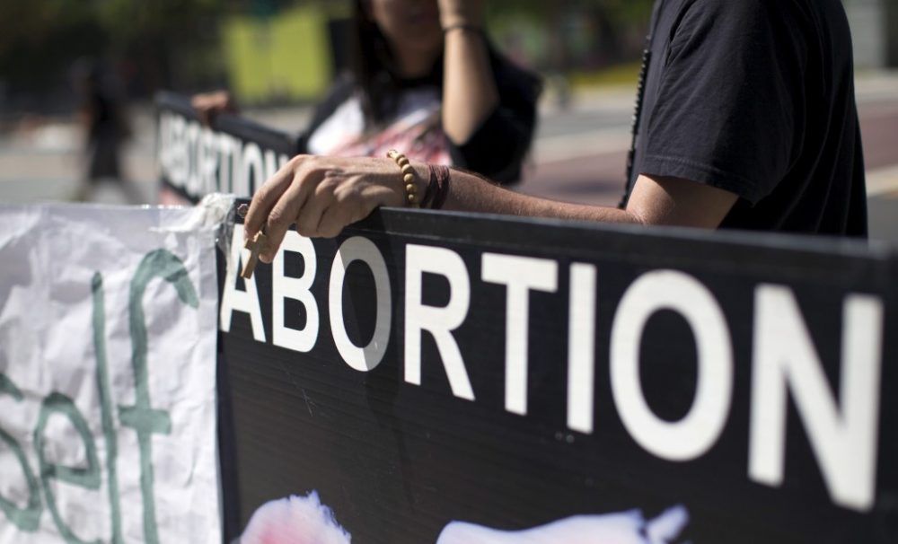 An activist holds a rosary while ralling against abortion outside City Hall in Los Angeles, California September 29, 2015. U.S. Congressional Republicans on Tuesday challenged Planned Parenthood's eligibility for federal funds, while the health organization's president said defunding it would restrict women's access to care and disproportionately hurt low-income patients. 