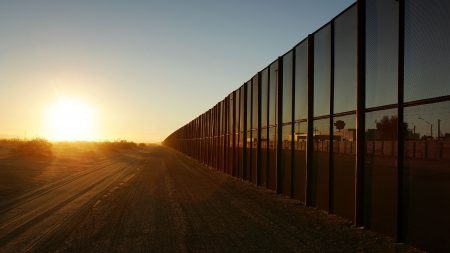 A metal fence runs along the U.S.-Mexico east of San Luis, Arizona.