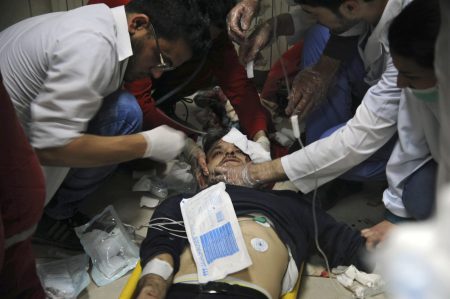 In this photo released by the Syrian official news agency SANA, shows a man receiving treatment at a hospital in Damascus, Syria, Saturday, April. 7, 2018. State TV said Army of Islam fighters pelted several neighborhoods in Damascus with mortar shells killing six civilians and wounding more than 30. (SANA via AP)