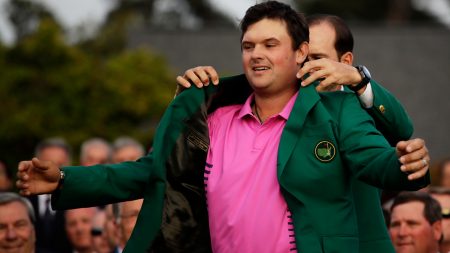 Former Masters champion Sergio Garcia, of Spain, helps Patrick Reed with his green jacket after winning the Masters golf tournament Sunday in Augusta, Ga.
