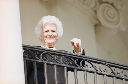 First lady Barbara Bush points towards the White House balcony where she was waiting for her husband as he returned home from a day trip from Columbia, S.C., Feb. 15, 1989 Bush addressed a joint session of the South Carolina state legislature. (AP Photo/Charles Tasnadi)