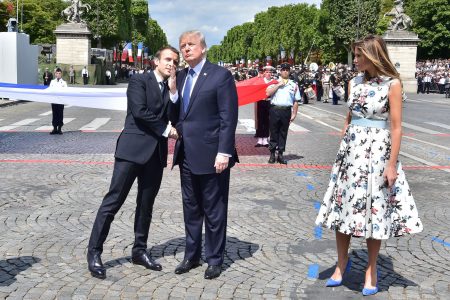 French President Emmanuel Macron (left) shakes hands with President Trump, next to first lady Melania Trump, during the annual Bastille Day military parade in Paris on July 14, 2017. Trump is hosting Macron in Washington this week for the first official state visit of his presidency.