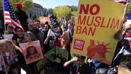Demonstrators rally in Washington, D.C., last fall against the Trump administration's travel ban, which is to be argued before the Supreme Court Wednesday