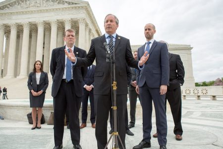 Texas Attorney General Ken Paxton, center, speaks on the steps of the U.S. Supreme Court with his team, including Texas Solicitor General Scott Keller, right, after arguments in Abbott v. Perez, a case over Texas' congressional and state House maps on April 24, 2018.