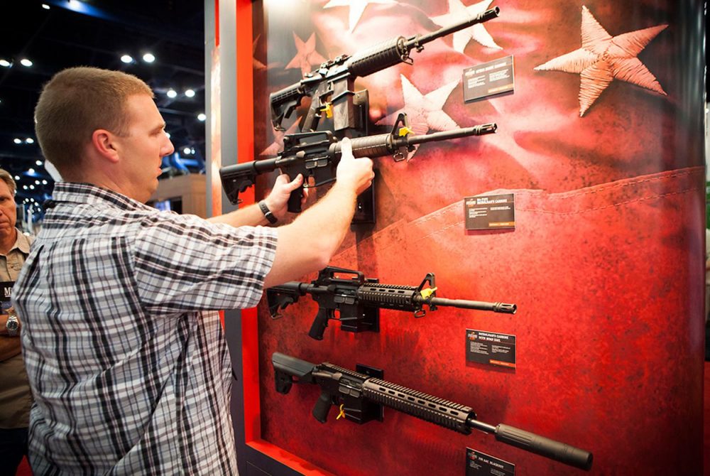 A man who declined to be identified looks at Bushmaster rifles at the NRA's national convention in Houston, Friday May 3, 2013.  