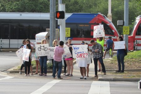 Cyclists protest in the crosswalk at Main and Sunset