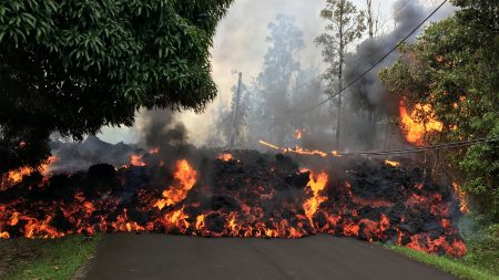 A lava flow moves on Makamae Street in the Leilani Estates subdivision on Sunday, following an eruption by Hawaii's Kilauea volcano. The governor of Hawaii has declared a local state of emergency and some 1,700 residents have been ordered to flee.