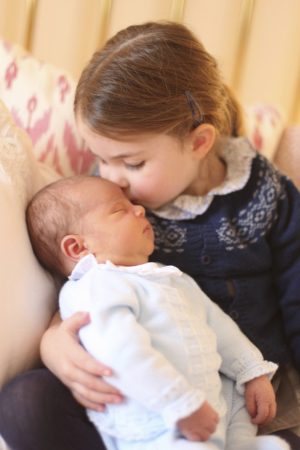 In this May 2, 2018 photograph provided by Kensington Palace, Britain's Princess Charlotte cuddles her brother Prince Louis, on her third birthday, at Kensington Palace, in London.