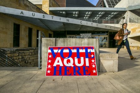 A pedestrian walks past Austin City Hall, an early voting center, in March. Texas was the first state to go to the polls to vote in midterm primaries.