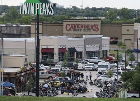 FILE - In this May 17, 2015, file photo, authorities investigate a shooting in the parking lot of Twin Peaks restaurant in Waco, Texas. A grand jury on Tuesday, Nov. 10, 2015, returned indictments for engaging in organized criminal activity against 106 of the 177 bikers arrested following the deadly shootout, the McLennan County district attorney said. (AP Photo/Jerry Larson, File)