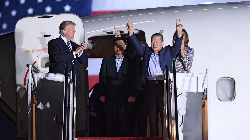 President Trump applauds as Kim Dong Chul (2nd R) gestures upon his return with Kim Hak Song (C) and Tony Kim (behind) after they were freed by North Korea, at Joint Base Andrews in Maryland.