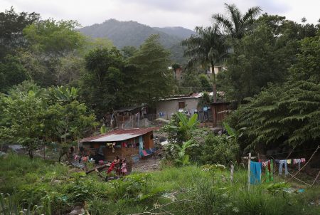 Families live by a creek in an impoverished neighborhood in San Pedro Sula, Honduras.