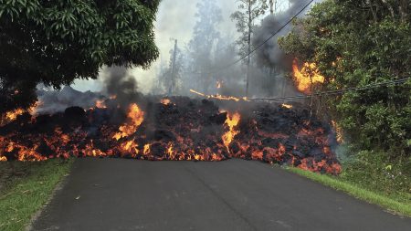 A lava flow on May 6 moves across Makamae Street in the Leilani Estates subdivision near Pahoa on the island of Hawaii. Kilauea volcano has destroyed more than two dozen homes since it began spewing lava hundreds of feet into the air last week.