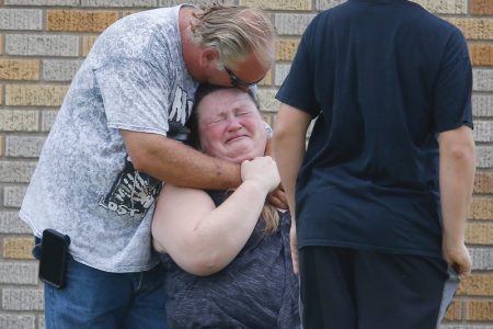 A man hugs a woman outside the Alamo Gym where parents wait to reunite with their kids following a shooting at Santa Fe High School. Michael Ciaglo/Houston Chronicle/Via NPR