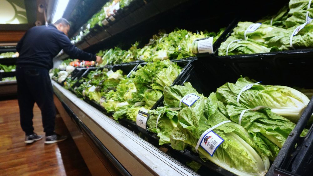 A man shops for vegetables beside romaine lettuce for sale at a supermarket in Los Angeles.
